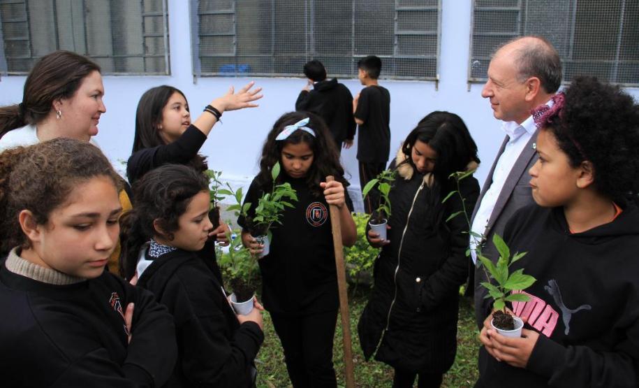 Ortega planta árvores junto com crianças e se emociona com o entusiasmo delas